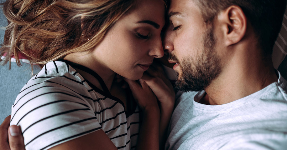 Woman and man closing their eyes about to kiss