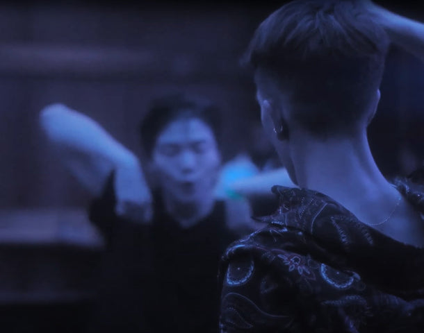 Deux danseurs de waacking s’exécutent sous une lumière bleue.