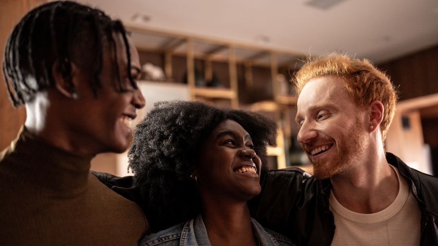 Trois personnes sourient en discutant ensemble de « ce qu’est une relation NME ».