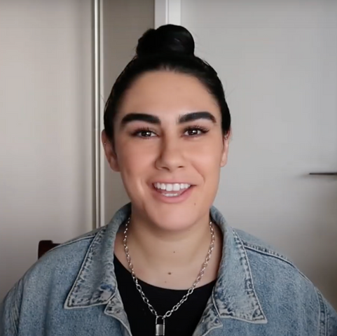 Breanne Williamson wearing a denim jacket and chain speaking into the camera