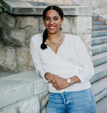 Natalya Mason adossée à un bâtiment de pierre et souriant à l’appareil photo.