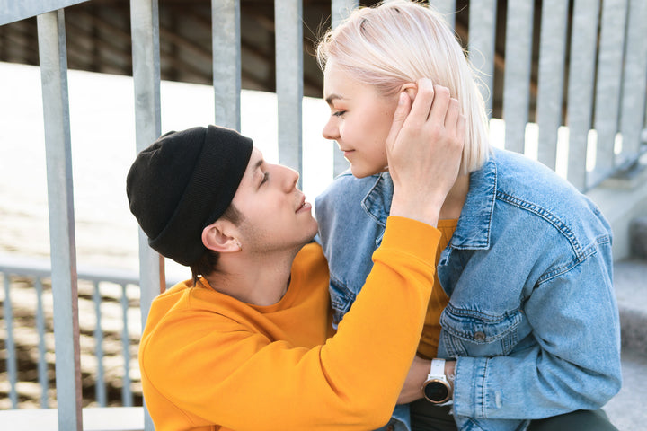 Man touching his partner's hair lovingly in public