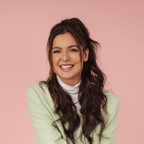 Karine St-Michel wearing a white turtleneck and mint jacket smiling into the camera