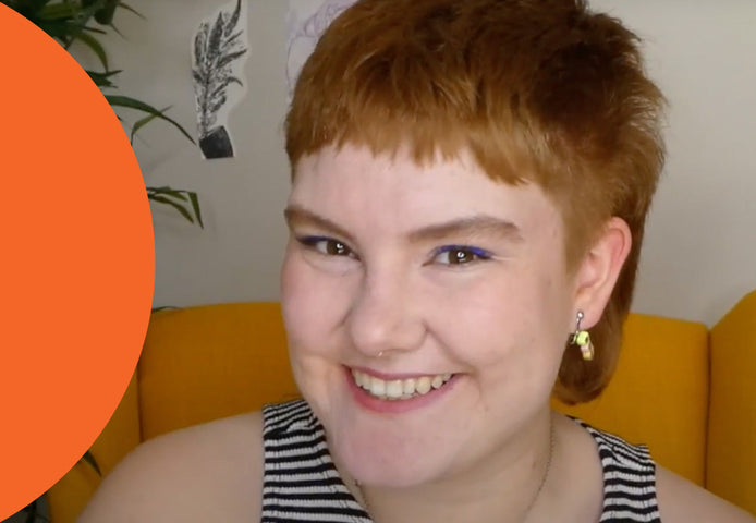 Eva Bloom portant une camisole à rayures et souriant à l’appareil photo.