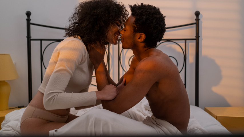 Couple going for a kiss in bed during a sexy slumber party.