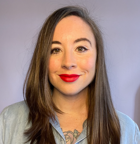 Headshot of Erica Smith wearing red lipstick against a wall