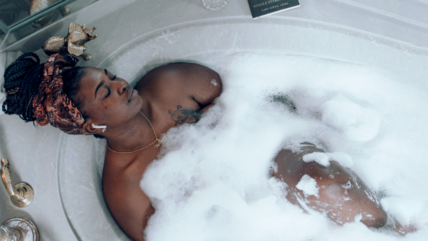 Woman closing her eyes while relaxing in a bubble bath.