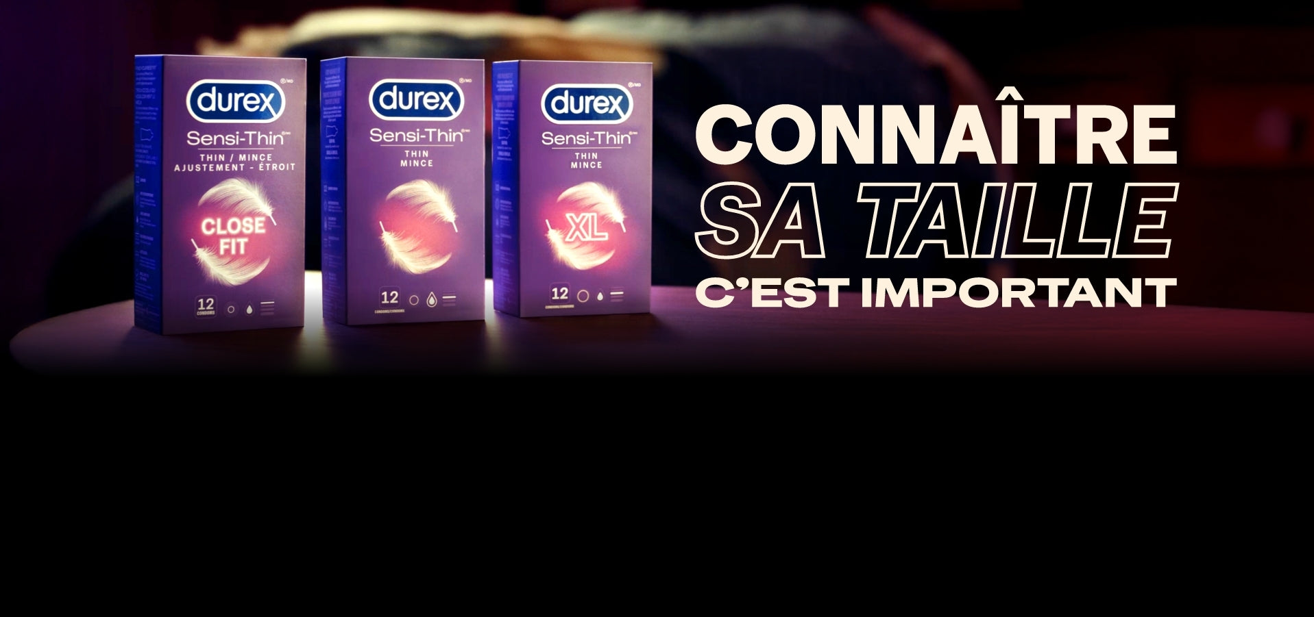 Trois boîtes de préservatifs Durex Sensi-Thin (tailles Close Fit, Thin et XL) sont présentées sur une table avec un texte en gras au-dessus qui dit « Connaître sa taille, c'est important »