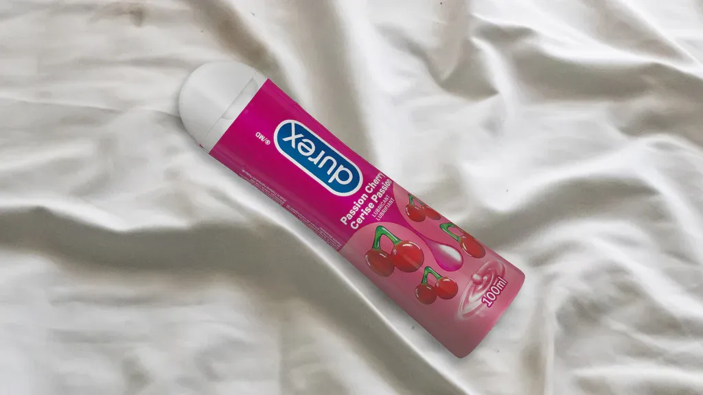 Une bouteille de lubrifiant Durex Cerise Passion sur un drap blanc.