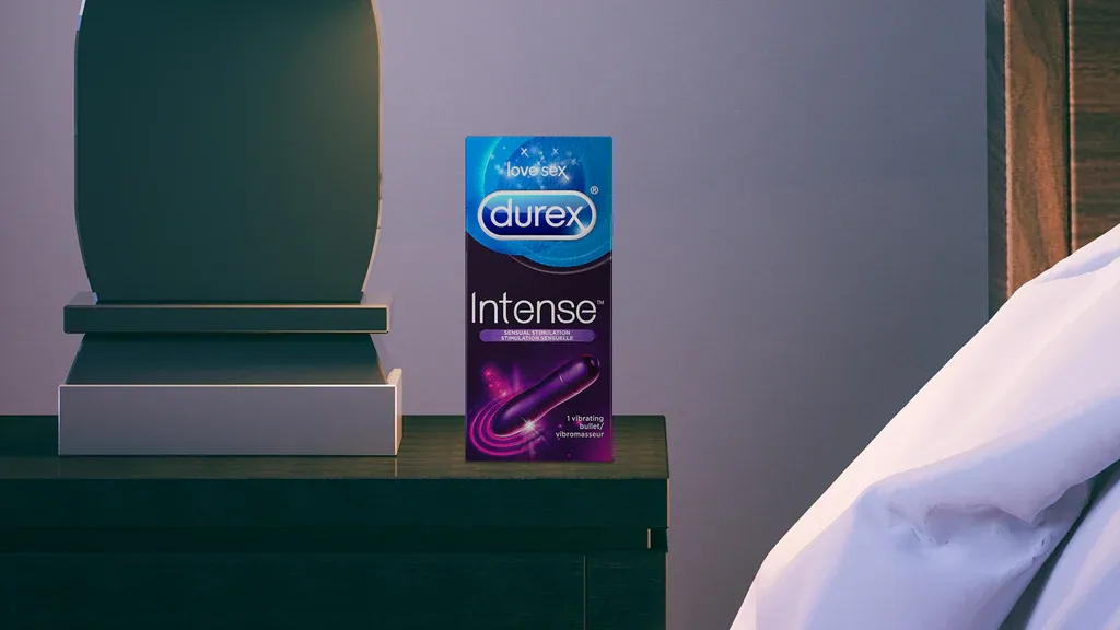 Un vibromasseur Durex Intense Stimulation Sensuelle dans son emballage sur une table de chevet.